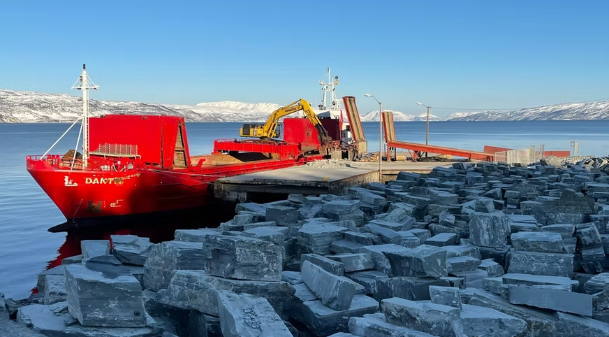Alta skiffer – hällar, plattor och mur i natursten Alta skiffer lastas vid hamn i norra Norge – natursten i form av hällar, plattor och murblock för trädgård och utomhusmiljö.